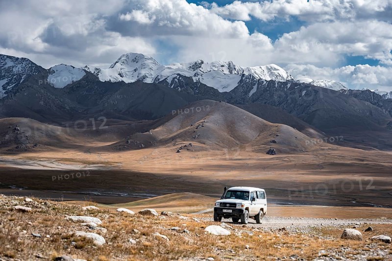 Off-road vehicle on a gravel track, glaciated and snow-covered peaks, Ak Shyrak Mountains, near Kumtor, Kara-Say, Tian Shan, Kyrgyzstan, Asia