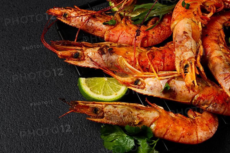 Langoustines, Australian, freshly frozen on ice, top view, lime and greens