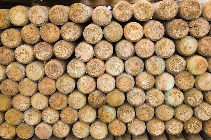 Wooden fence posts piled up in a builder's merchant yard, UK
