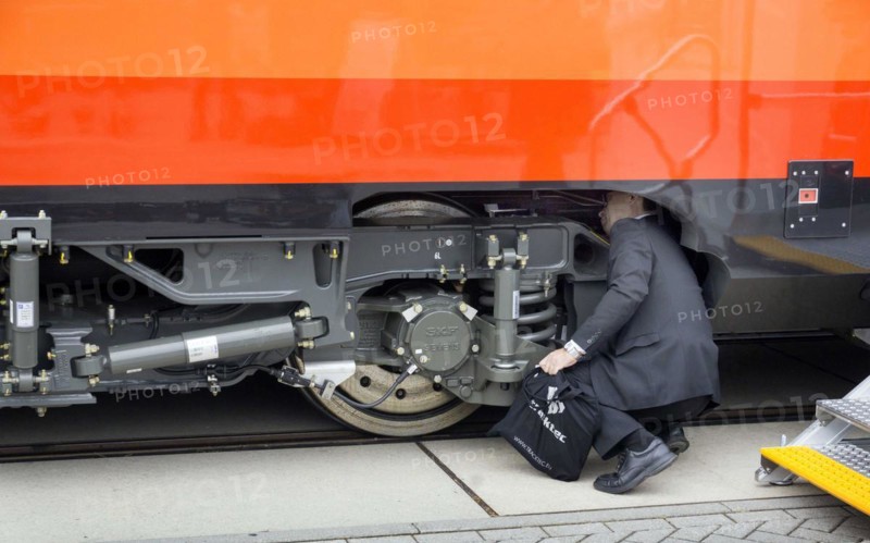 Chinese visitors to the InnoTrans trade fair in Berlin take a look at the undercarriage under a railway carriage, 20/09/2016