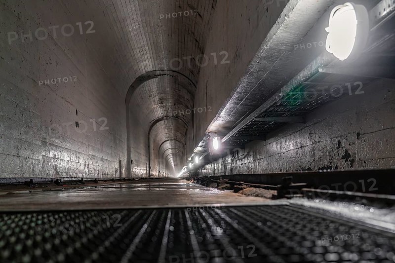 Concrete tunnel with long perspective to the inside, illuminated by lamps at the sides, humid environment, Rappbode Dam, Harz Mountains, Germany, Europe