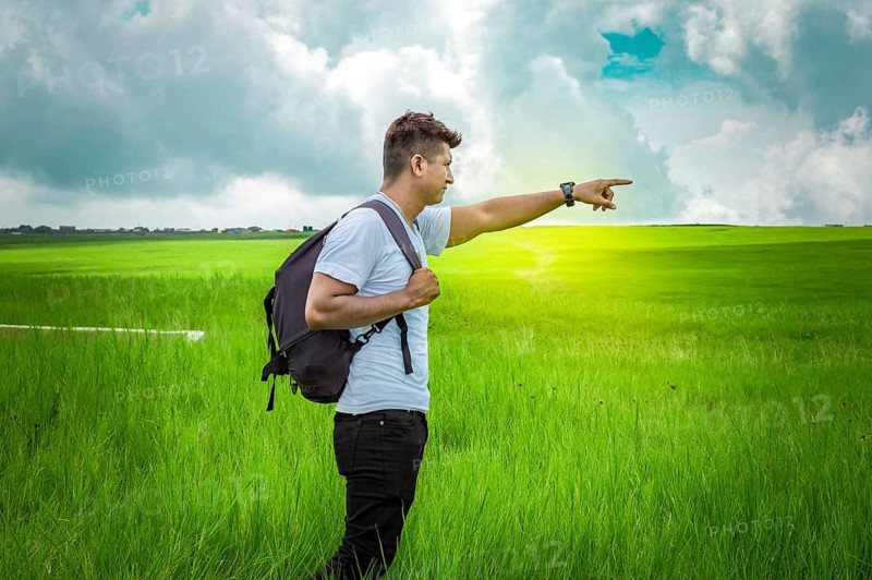 Adventurous man in the field, man with backpack in the field looking
