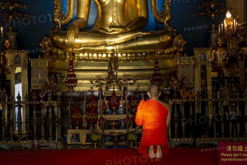 Monk meditating in front of the Phra Buddha Chinnarat, Buddha statue with Bhumispara-mudra, Buddha Gautama at the moment of enlightenment, Wat Benchamabophit, also: marble temple, Dusit district, Bangkok, Thailand, Asia