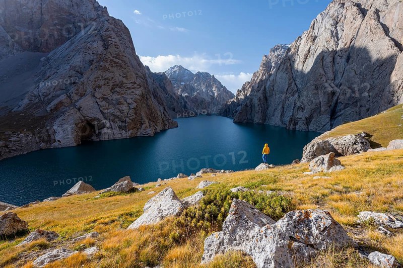 Tourist at the blue mountain lake between rocky steep mountain peaks, Kol Suu Lake, Sary Beles Mountains, Naryn Province, Kyrgyzstan, Asia