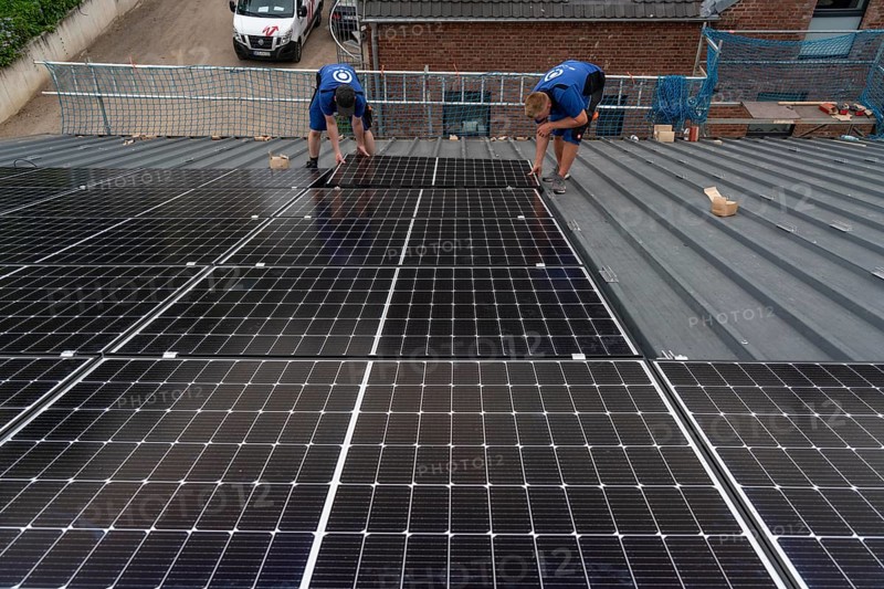 Installation of solar modules on the roof of a barn on a farm, over 240 photovoltaic modules are installed on the roof, North Rhine-Westphalia, Germany, Europe