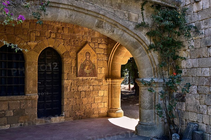 Monastery of Our Lady of Mount Filerimos, A stone archway of a medieval church with a dark door, icon and climbing plants in the sunlight, Filerimos, hill not far from Rhodes Town, Ancient State of Ialyssos, Rhodes, Dodecanese, Greek Islands, Greece, Europe