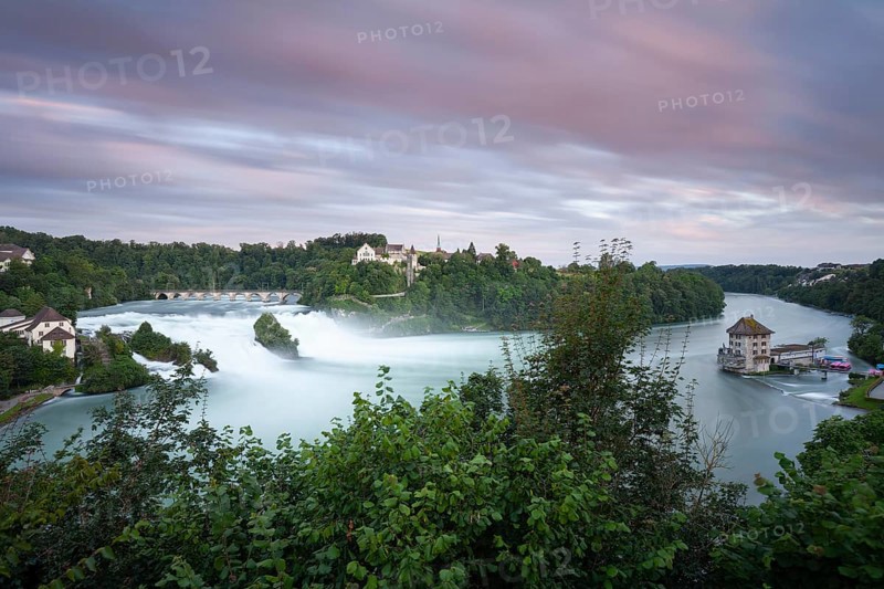 The Rhine Falls at Schaffhausen in Switzerland at sunset with Laufen Castle on the Rhine Falls. An extreme amount of water in 2024