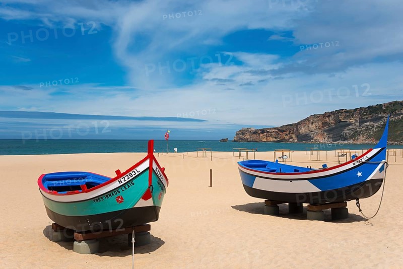 Two fishing boats on the sandy beach of Nazaré with a view of the sea and the cliffs, Praia da Nazare beach, Nazaré, Oeste, Leiria district, Centro, Extremadura, Portugal, Europe