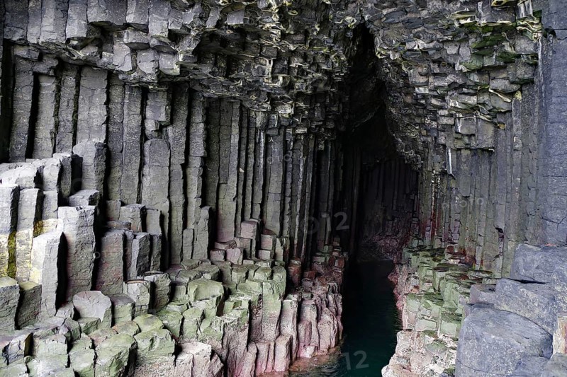 Dark cave with impressive basalt columns and deep water in a natural setting, Staffa, Inner Hebrides, Scotland, United Kingdom, Europe
