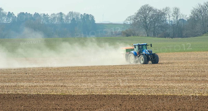 Spring farming, spreading fertilizer with tractor on field in Ystad municipality, Skåne county, Sweden, Scandinavia, Europe