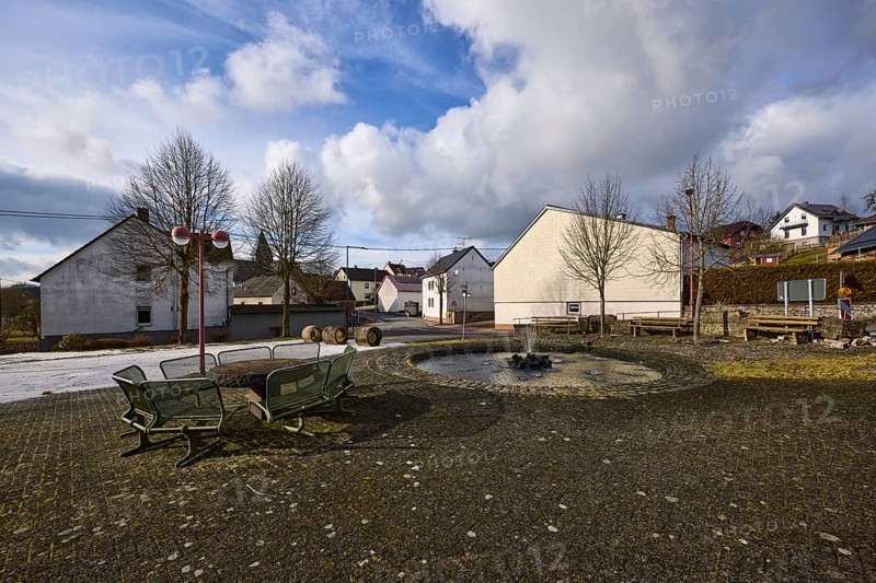 Village fountain, benches, lantern, trees, houses, blue sky, cumulus clouds, cirrostratus clouds, street Im Höfchen and main street, Dreis-Brück, Eifel, district Vulkaneifel, Rhineland-Palatinate, Germany, Europe
