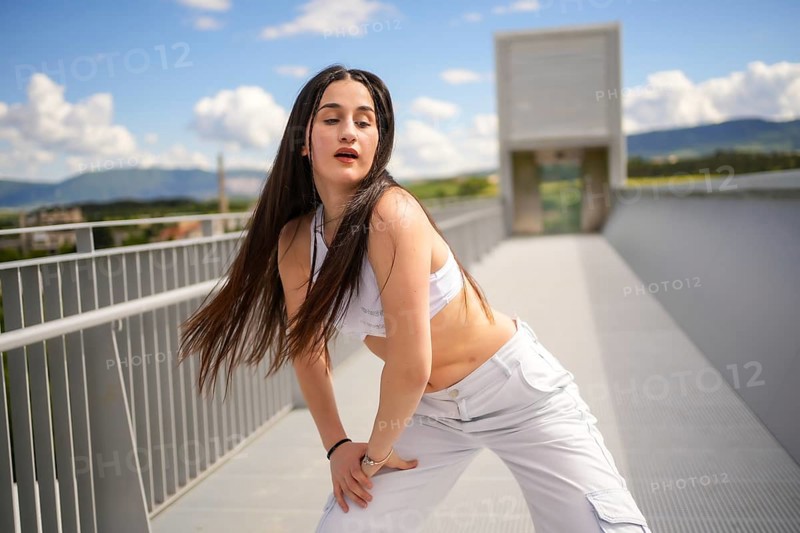 Three quarter length portrait of a caucasian beauty young woman performing urban dance in an outdoor urban bridge