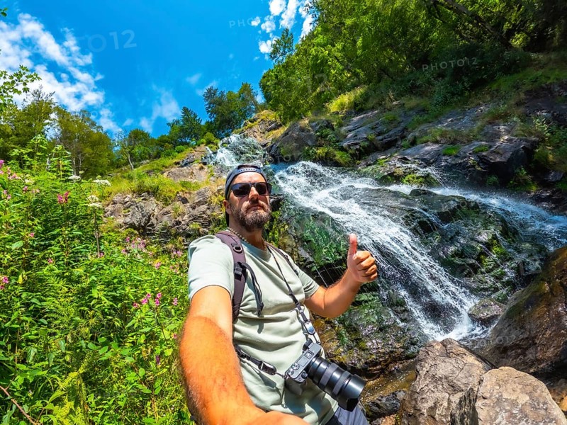 Selfie of a tourist man in summer at the Todtnau waterfall in the Black Forest in Germany