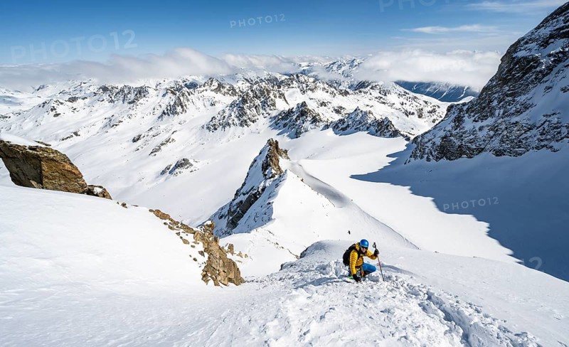 Mountaineer with ice axe and crampons, ascent through steep snowfield to Piz Kesch or Piz d'Es-cha in winter, view of mountain panorama with Vadret da Porchabella glacier, Albula Alps, Rhaetian Alps, Grisons, Eastern Switzerland, Switzerland, Europe