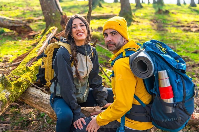 Hikers taking a break in the woods during a trekking excursion, enjoying the peace of nature