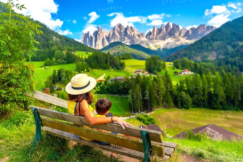 Tourists enjoying breathtaking views of the italian alps in the picturesque val di funes, with the iconic odle mountain range in the background