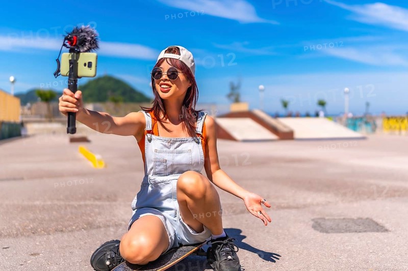 Chinese young female streamer vlogging online in a skate park
