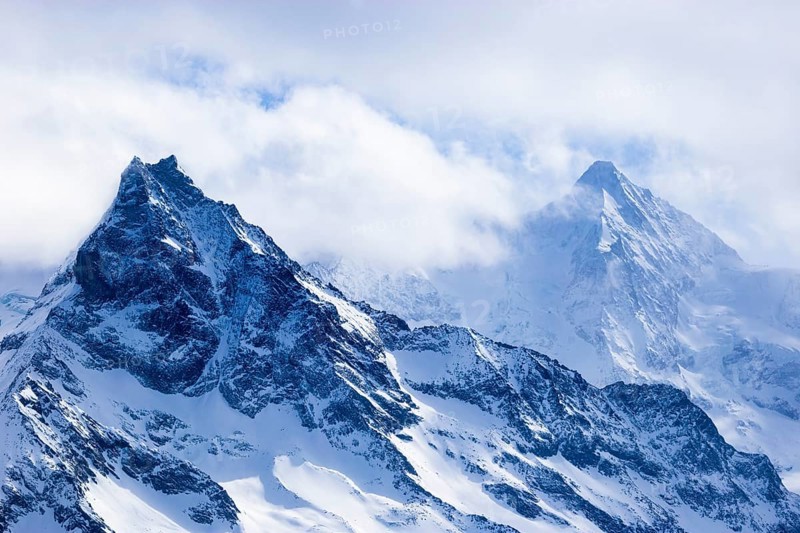 Wisps of mist surround the snow-covered peaks of the mountains Le Besso and Obergabelhorn, Val d'Anniviers, Valais Alps, Canton Valais, Switzerland, Europe