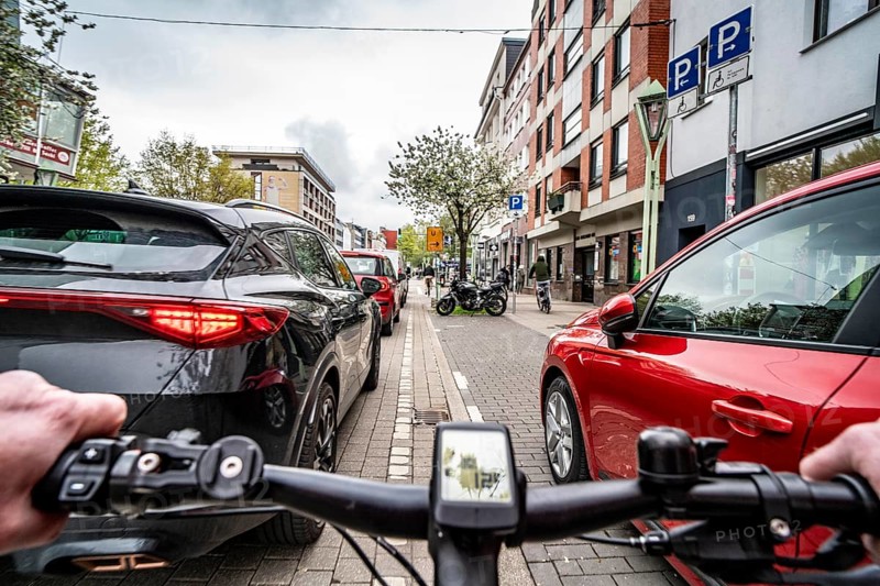 Cycling in the city, inner-city street, cycle lane, bicycles have priority, two-lane traffic with parked cars on both sides, cyclists' perspective, Essen, North Rhine-Westphalia, Germany, Europe