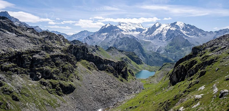 Mountain stream and mountain lake Lac de Louvie with glaciated summit of the Grand Combin, Val de Bagnes, Valais, Switzerland, Europe