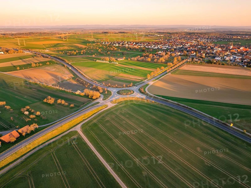 Shaded fields and a roundabout near a village at sunset, Nagold, Black Forest, Germany, Europe