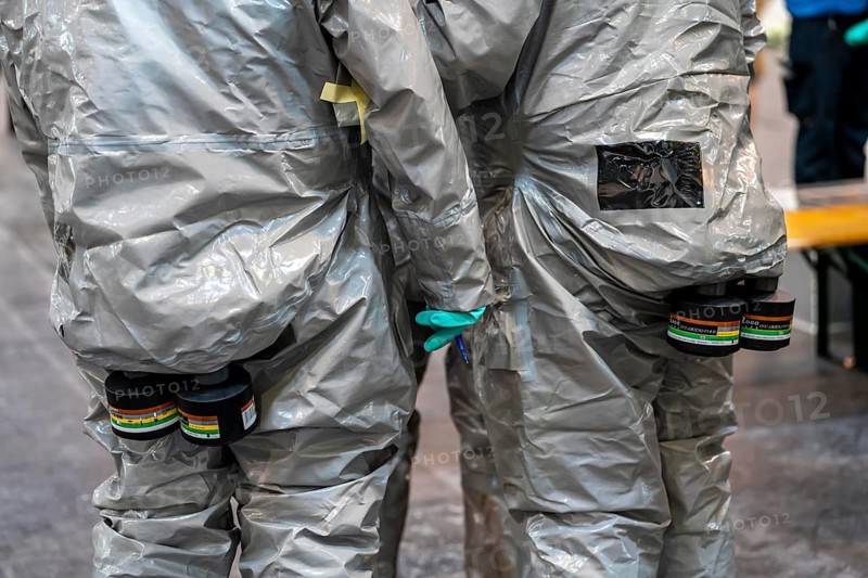 Decontamination of injured persons after an assumed accident involving hazardous substances, fire brigade and aid organisations practise setting up and operating a decontamination station, injured persons are sighted and then washed in a special shower tent to remove possible hazardous substances and chemicals in order to avoid further injuries, the emergency services wear special, ventilated protective suits, large-scale exercise by the Essen fire brigade