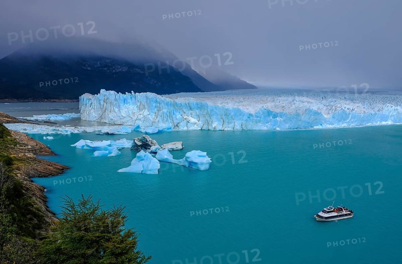 El Calafate, Patagonia, Argentina, Perito Moreno Glacier in Los Glaciares National Park. The Perito Moreno Glacier is part of the Patagonian ice field, the Campo Hielo Sur, the third largest freshwater reserve in the world. It is located in the province of Santa Cruz on Lago Argentino, the country's largest lake. The Perito Moreno Glacier is up to 30 kilometres long and 5 kilometres wide. Its edge is 70 metres high at its highest point. Small icebergs that have broken off from the glacier float in Lago Argentino. The glacier is one of the most beautiful sights in South America and is one of the most visited attractions in Argentina. Tourists can take an excursion boat to the glacier, South America