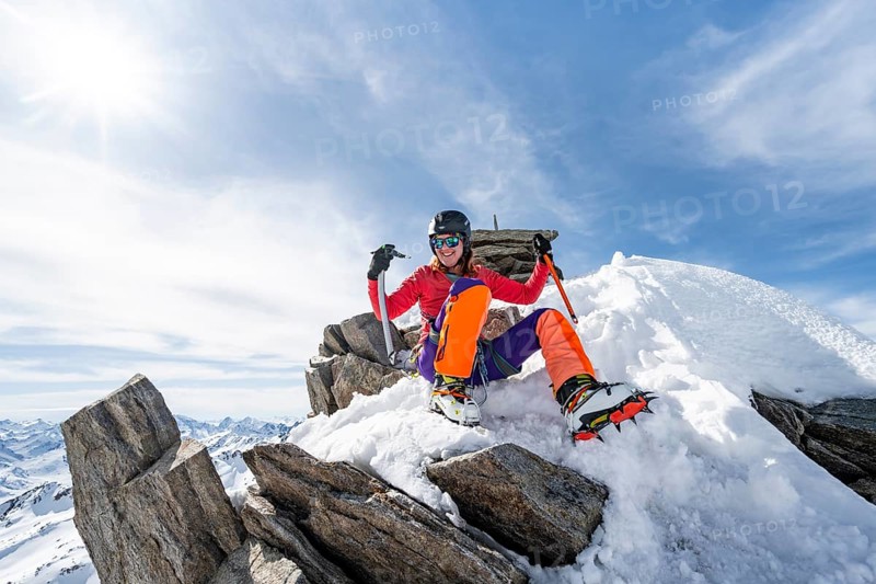 Happy mountaineer with ice axes and crampons on the summit of Piz Grialetsch in winter, Graubünden Haute Route, Albula Alps, Rhaetian Alps, Graubünden, Switzerland, Europe