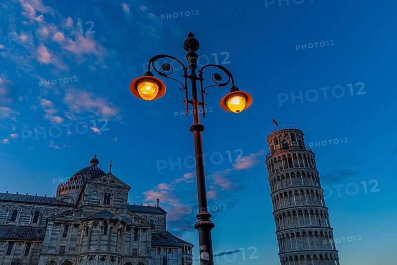 The Cathedral of Santa Maria Assunta and the Leaning Tower under an illuminated street lamp in the evening light, Pisa, Tuscany, Italy, Europe