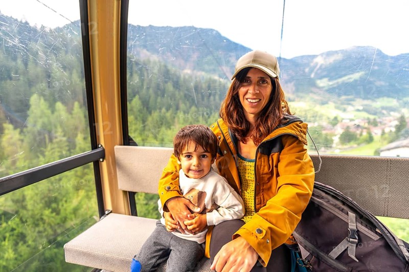 Tourists enjoying a scenic cable car ride in the italian dolomites, taking in the breathtaking mountain views