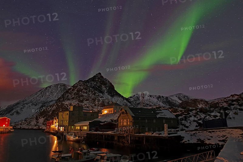 Night scene with northern lights in the sky, snow-covered mountains and houses by the water, winter, Nyksund, Langoya, Vesteralen, Nordland, Norway, Europe