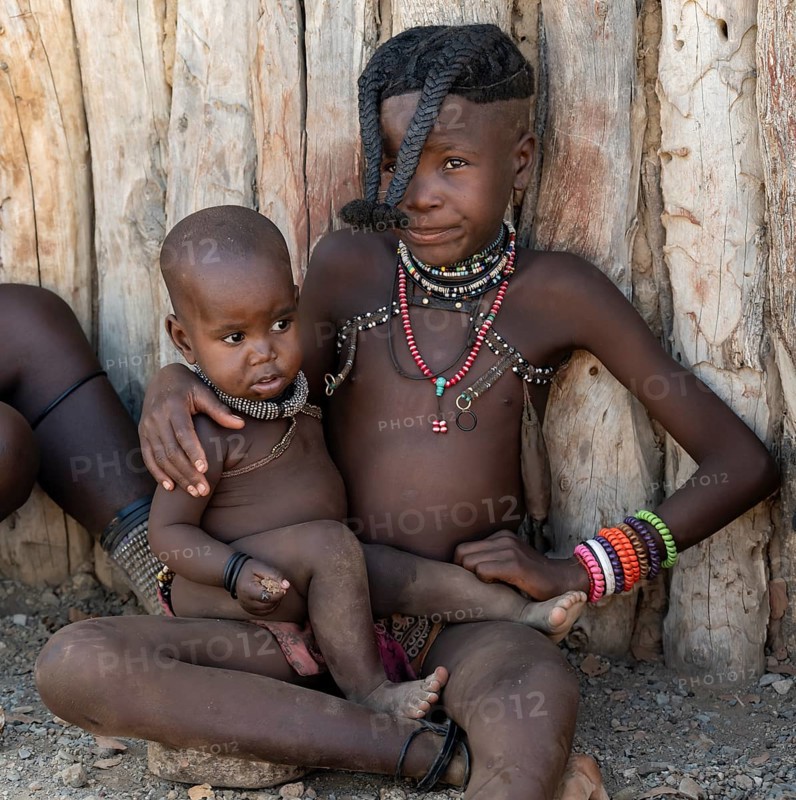 Himba girl with forward braided plaits with baby, near Opuwo, Kaokoveld, Kunene, Namibia, Africa
