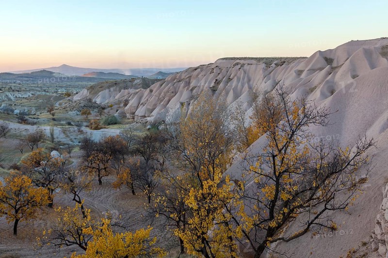 Twilight landscape with rocks and autumn trees in a hilly area, Cappadocia, Turkey, Asia