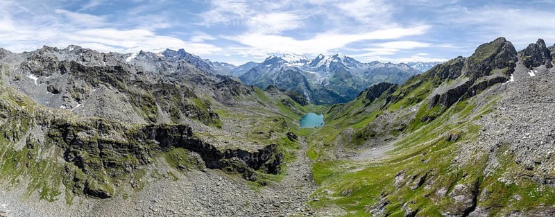 Alpine panorama, aerial view, mountain stream and mountain lake Lac de Louvie with glaciated summit of the Grand Combin, Val de Bagnes, Valais, Switzerland, Europe