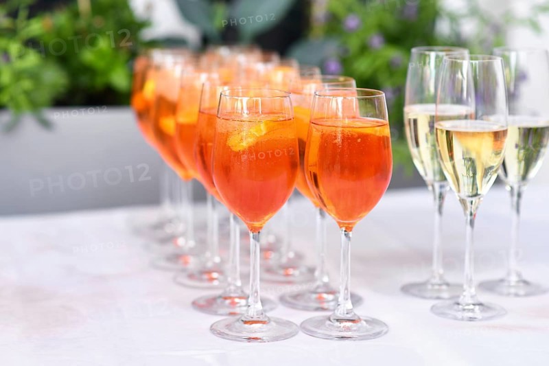 Glasses with orange colored Spritz, a wine-based cocktail drink on table in restaurant at wedding