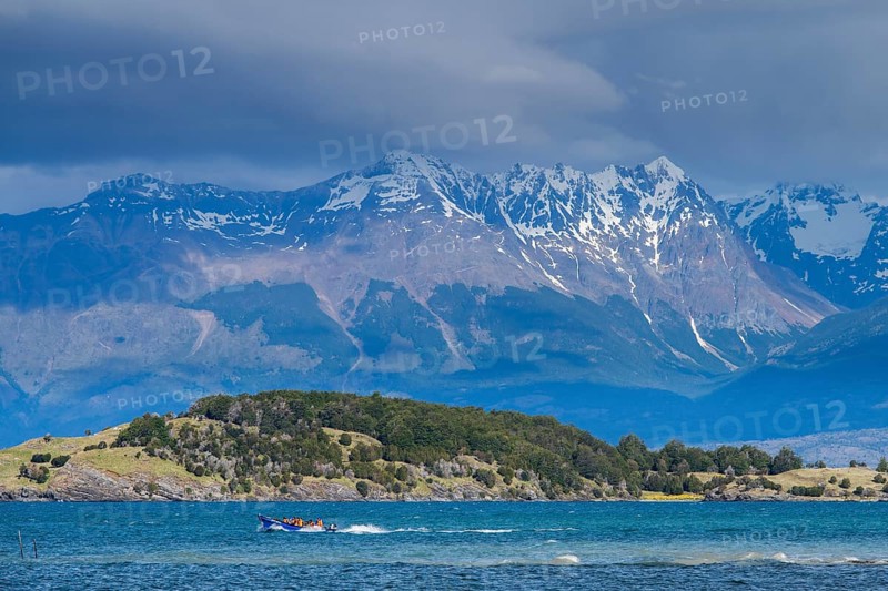 Motorboat with tourists travelling fast on the lake Lago General Carrera, also Lago Chelenko, snow-covered mountains behind, Puerto Rio Tranquilo, Aysen region, Patagonia, Chile, South America