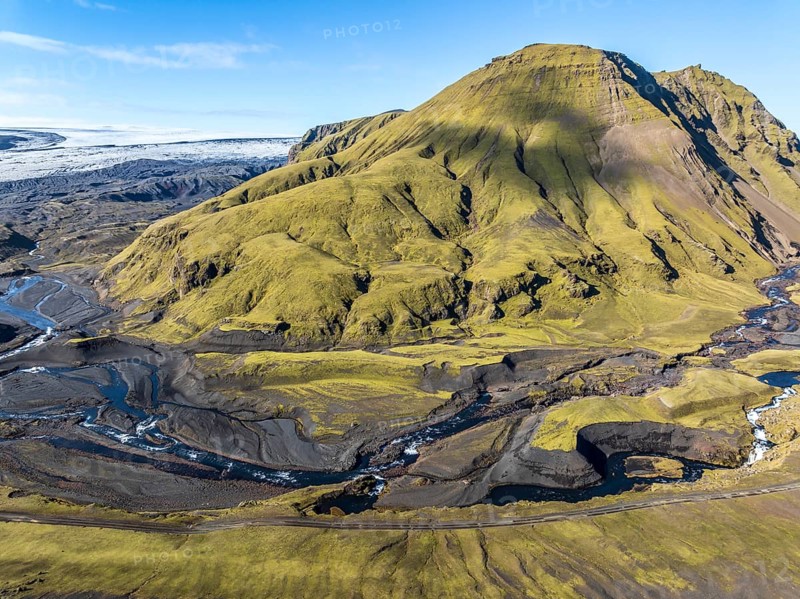 River along road F232 Öldufellsleid, slopes of Mt. Öldufell, moss-covered hill in black lava sand, aerial view, Iceland, Europe