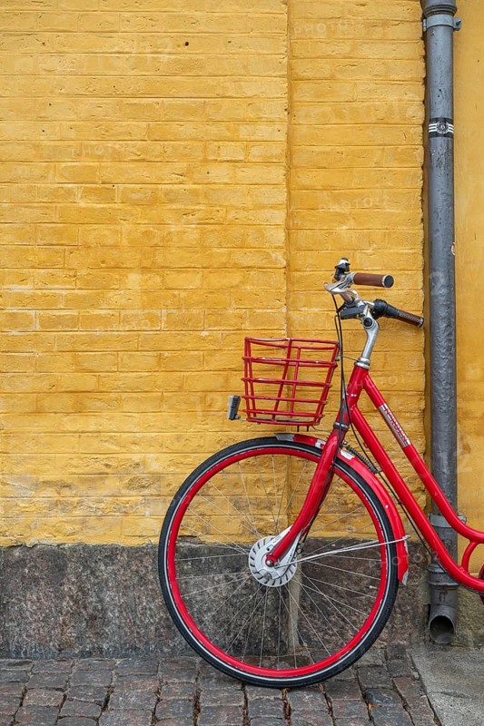 Red bicycle in front of yellow wall, heritage-protected building Søkvæsthuset, former naval hospice, Christianshavn Canal, Christianshavn, Copenhagen, Denmark, Europe