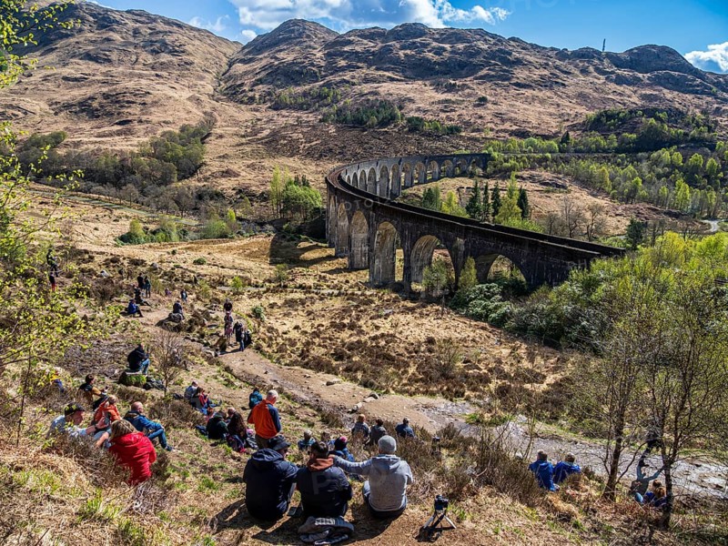 Tourists waiting for the jacobite steam train at the Glenfinnan viaduct, scottish highland, Scotland, UK