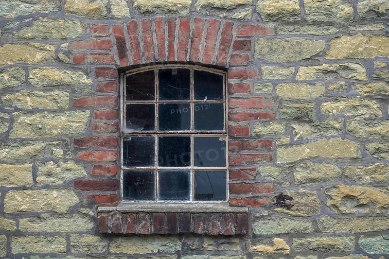 Single window embedded in a masonry stone wall with brick frame in an old farmhouse, North Rhine-Westphalia, Germany, Europe