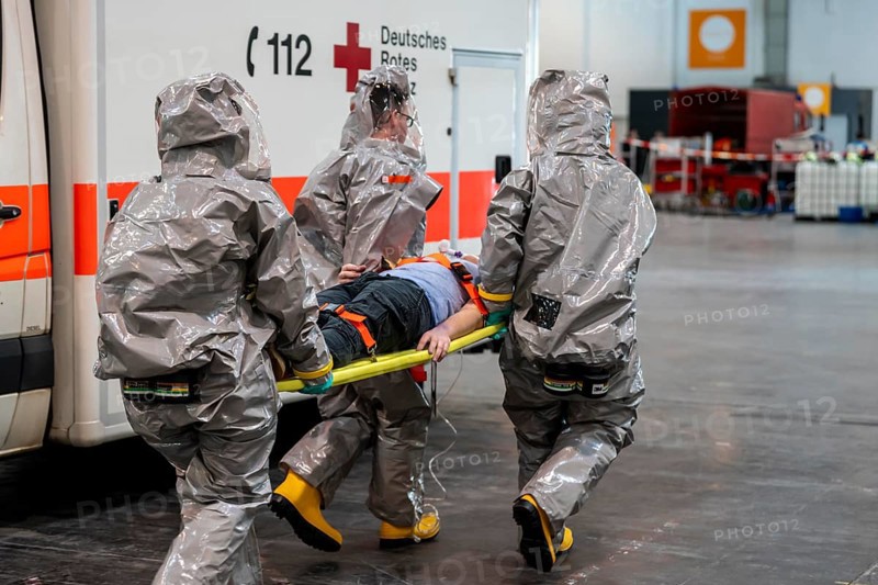 Decontamination of injured persons after an assumed accident involving hazardous substances, fire brigade and aid organisations practise setting up and operating a decontamination station, injured persons are sighted and then washed in a special shower tent to remove possible hazardous substances and chemicals in order to avoid further injuries, the emergency services wear special, ventilated protective suits, large-scale exercise by the Essen fire brigade