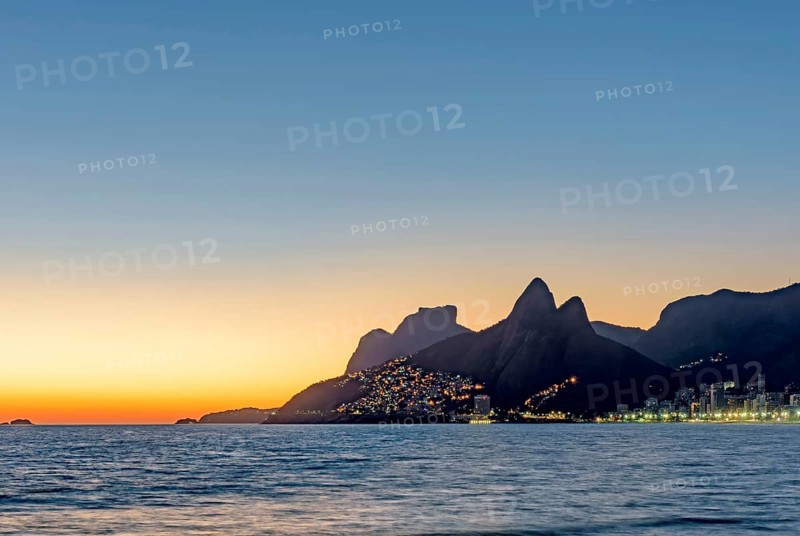Buildings illuminated during sunset on Ipanema beach in Rio de Janeiro, Ipanema beach, Rio de Janeiro, Rio de Janeiro, Brazil, South America