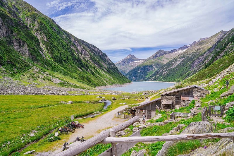 View of a mountain landscape with a lake, huts and a path through a green meadow, Klein Tibet, Zillertal, Austria, Europe