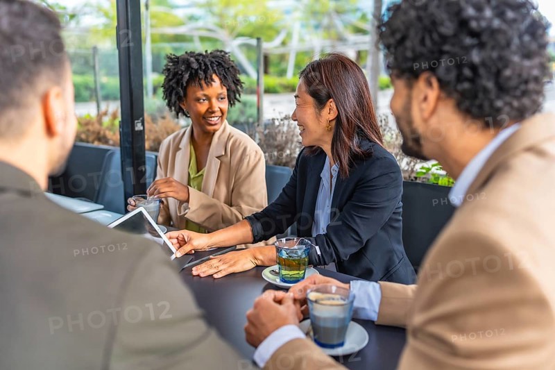 Business people using digital tablet during a meeting in a modern cafeteria