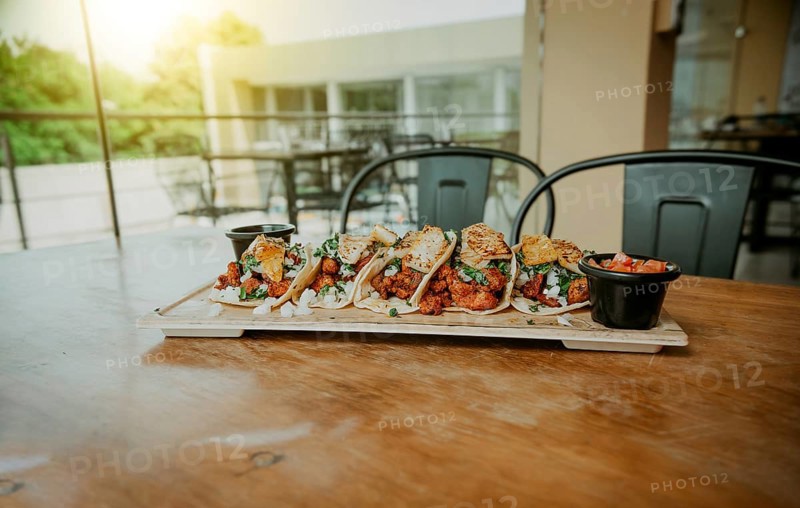 Delicious Mexican chicken tacos with sauces served on table restaurant. Traditional tacos al pastor with sauces served on a wooden board