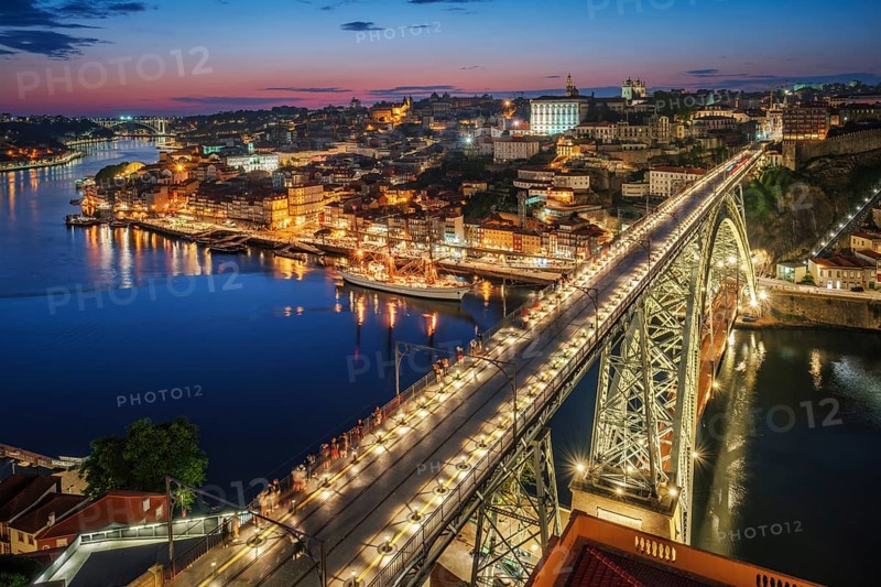 View of illuminated Porto city and Douro river and Dom Luis bridge I from famous tourist viewpoint Miradouro da Serra do Pilar in evening twilight. Porto, Vila Nova de Gaia, Portugal, Europe