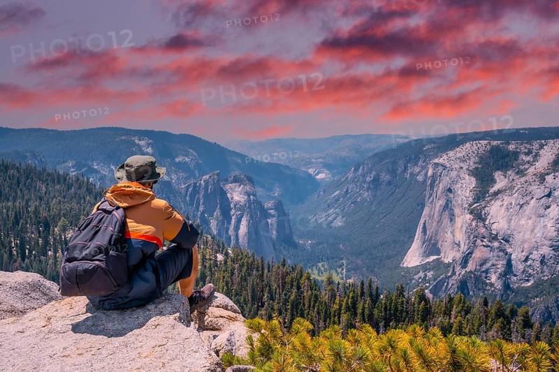 A young winged seated Taft point looking at Yosemite National Park and El Capitan in sunset. United States