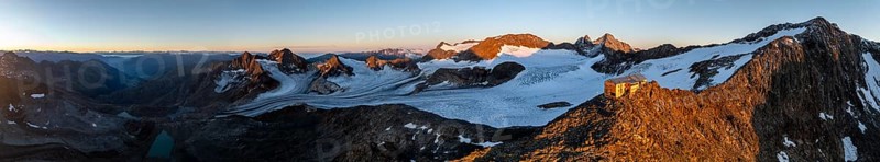 PanoraAtmospheric sunrise in picturesque mountain landscape, alpenglow, aerial view, mountain hut Becherhaus at the summit Becher and glacier Übeltalferner, Stubai Alps, South Tyrol, Italy, Europe