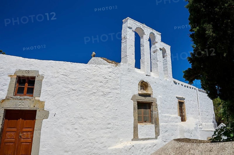 White church with bell tower and wooden door in front of a bright blue sky, Chora, Old Town, Patmos, Dodecanese, Greek Islands, Greece, Europe