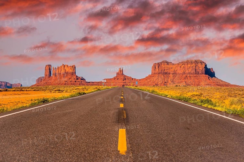Sunset in the road with its yellow lines of Monument Valley, Utah